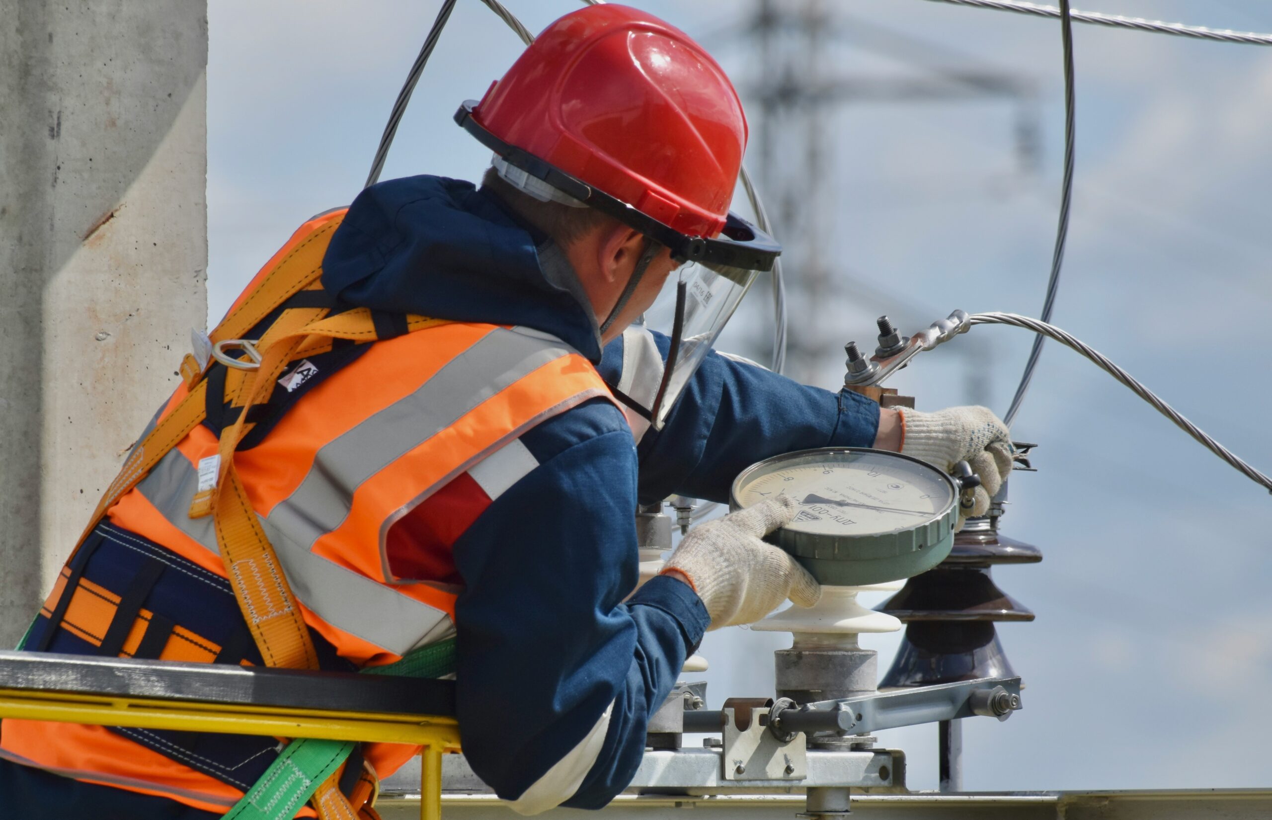 An experienced electrician assembling a site work portfolio and reviewing blueprints during a City & Guilds 2346-03 Electrical Experienced Worker Assessment Level 3 qualification.