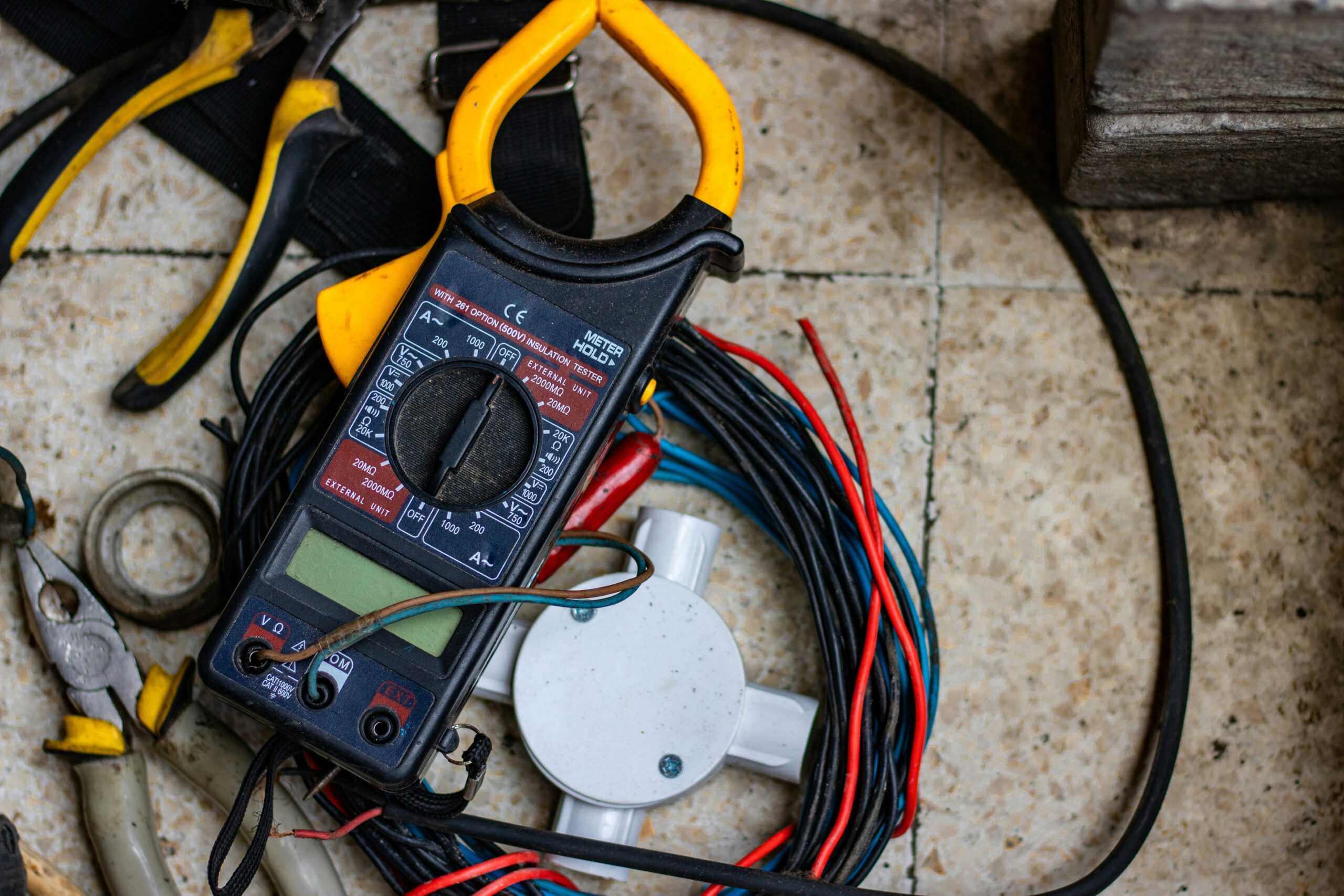 A professional electrician studying the orange-covered 2026 IET Wiring Regulations book during a City and Guilds 2382-22 18th Edition training course