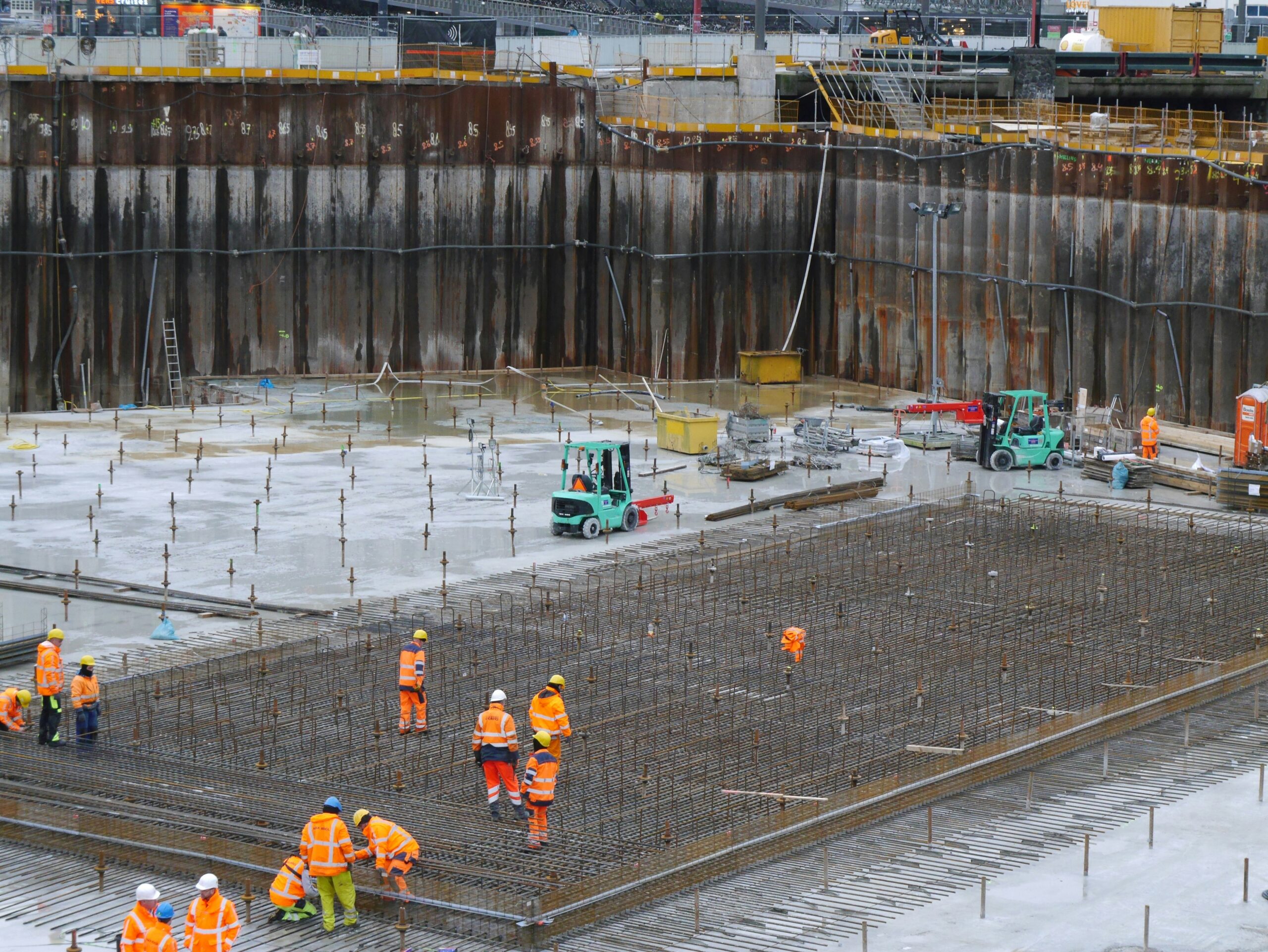 Construction labourers laying drainage pipes on a UK site to complete their NVQ Ground Works portfolio.