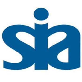 A professional male UK security guard wearing a high-visibility jacket with an official SIA license badge clearly displayed on his arm.