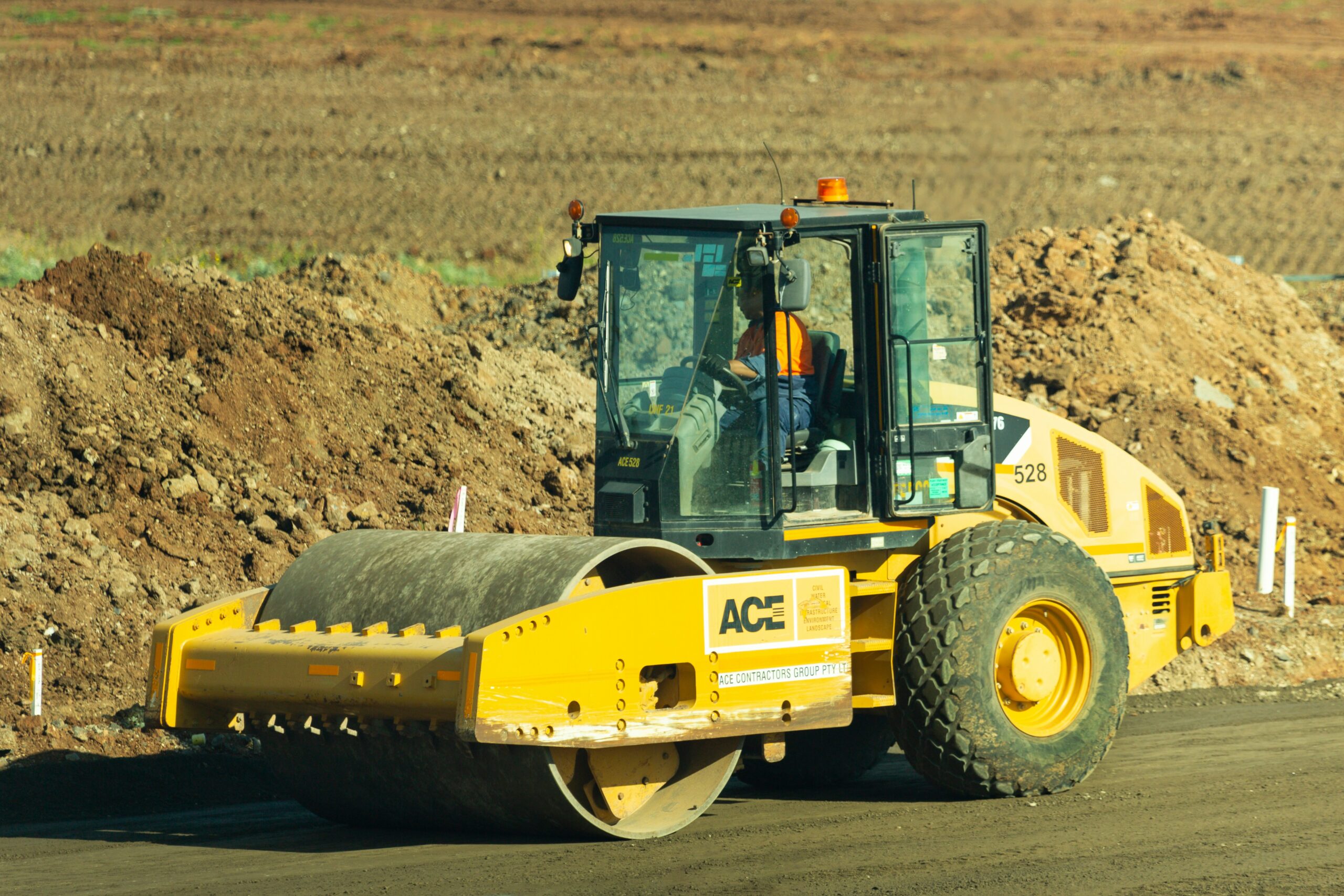 A specialist operative participating in professional plant operator training using a 360 slew rotating telescopic handler on a busy construction site.
