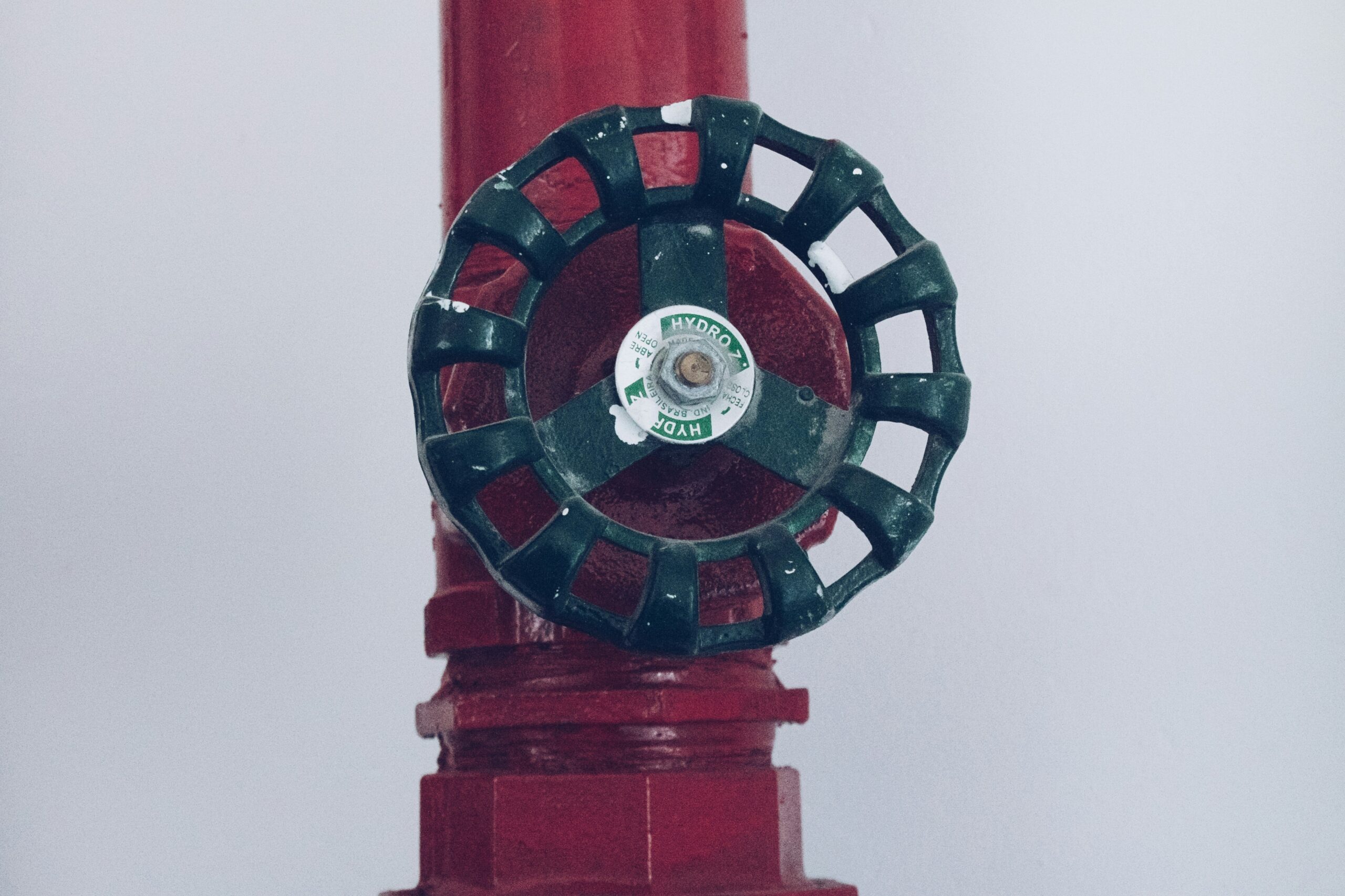 A property manager reviewing a safety compliance checklist near commercial fire sprinkler systems pipework.