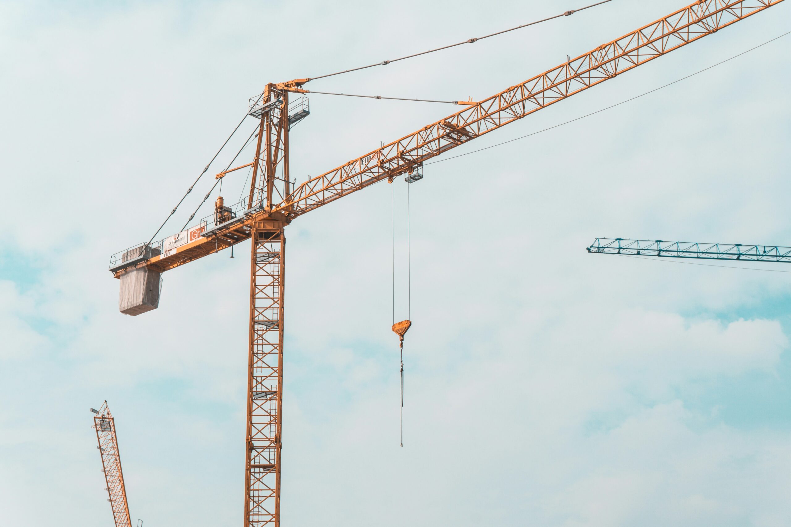 A qualified site professional supervising a mobile crane operation in the UK to achieve their CPCS NVQ Lift certification.