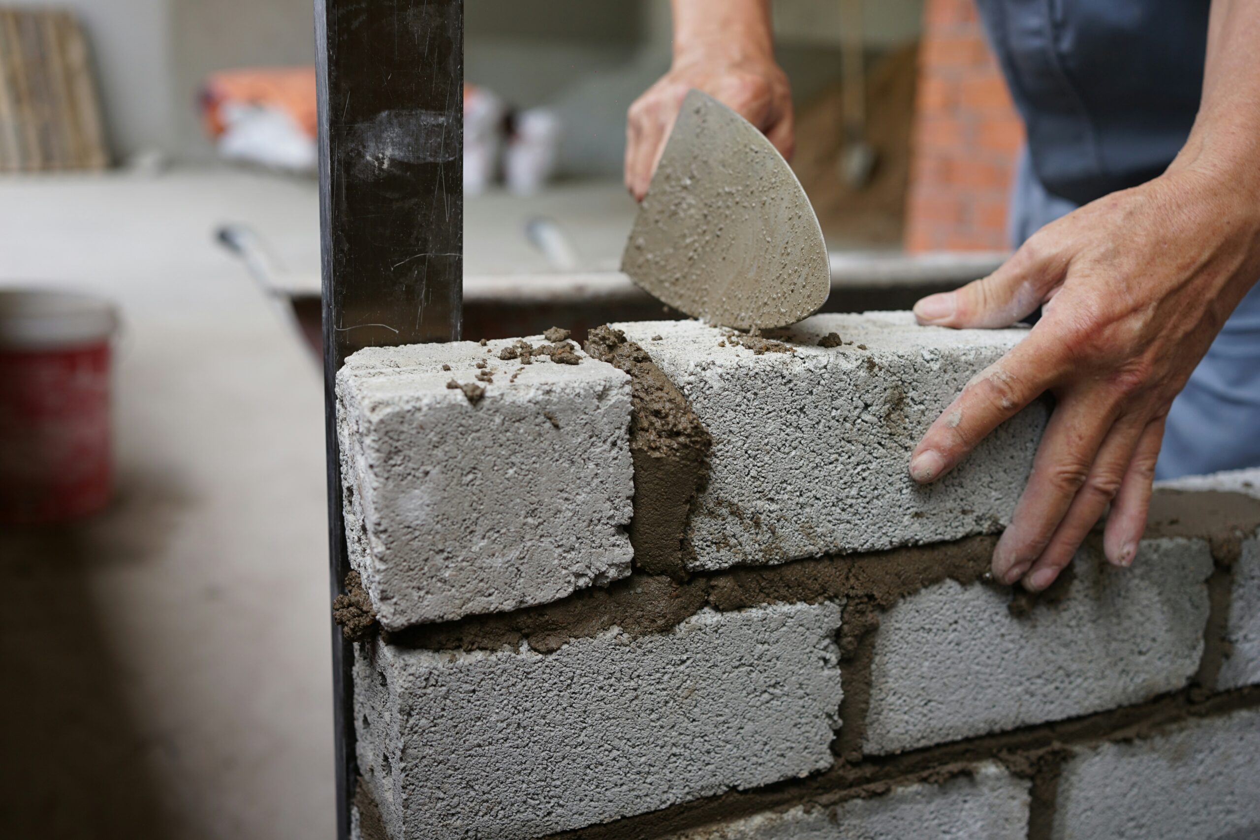 A professional tradesperson smoothing fine finish skim coat to fulfill his plastering nvq course requirements.